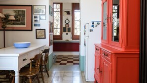 Una cucina con un armadio rosso, un piano di lavoro bianco e un pavimento a scacchi.