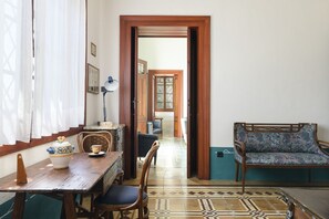 A room with a wooden dining table, chairs, a sofa, and a patterned floor. - Villino alla Croce by Wonderful Italy (Ostuni)