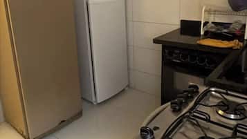 A kitchen with a refrigerator, a stove, and a sink.