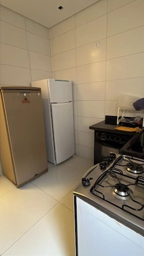 A kitchen with a refrigerator, a stove, and a sink.