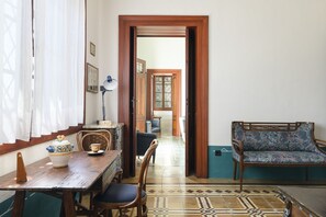 Une pièce comprenant une table à manger en bois, des chaises, un canapé et un sol à motifs.
