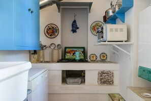 A compact kitchen with a gas stove, a coffee machine, and various kitchen utensils. - Villino Alla Croce by Wonderful Italy (Ostuni)