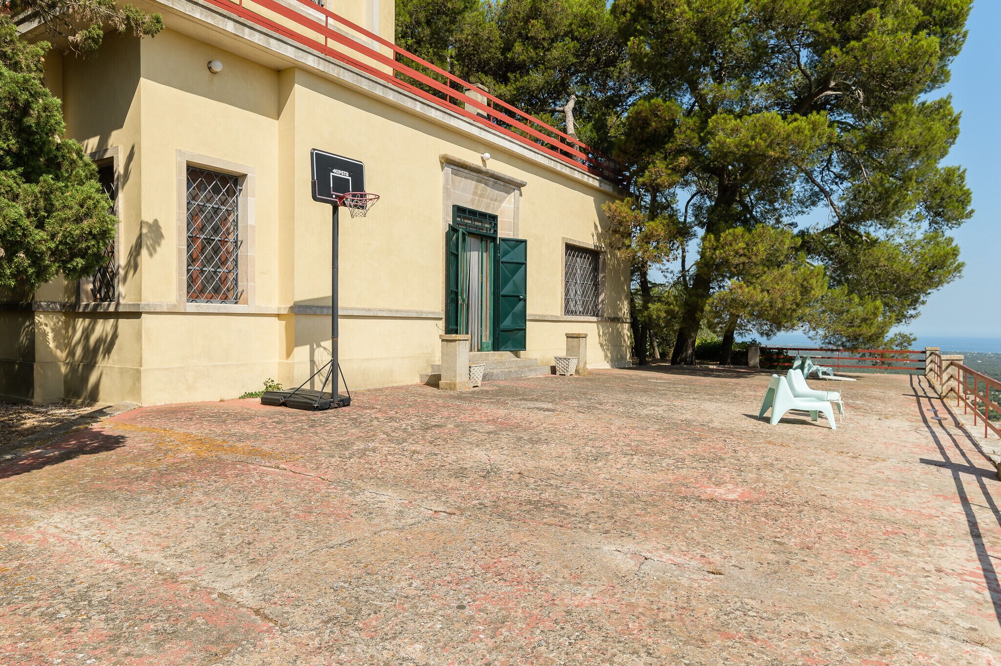 Edifici amb cistella de bàsquet, una porta i una cadira.