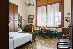 A room with a bed, a desk, chairs, a dresser, a lamp, and a window with curtains. - Villino Alla Croce by Wonderful Italy (Ostuni)