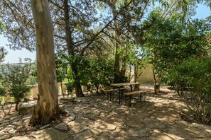 An outdoor seating area with stone flooring and wooden benches. - Villino Alla Croce by Wonderful Italy (Ostuni)