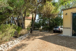 A gravel driveway leading to a building with a stone wall on one side. - Villino Alla Croce by Wonderful Italy (Ostuni)