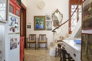 Une cuisine équipée d’un réfrigérateur, de chaises, d’un escalier et d’une table à manger.