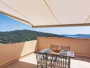 Ein Balkon mit Tisch für zwei Personen, mit Blick auf eine Berglandschaft.