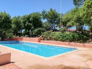 A rectangular swimming pool with clear blue water, surrounded by terracotta tiles and a low brick wall. - Village de Silhouette by Interhome (Grimaud)