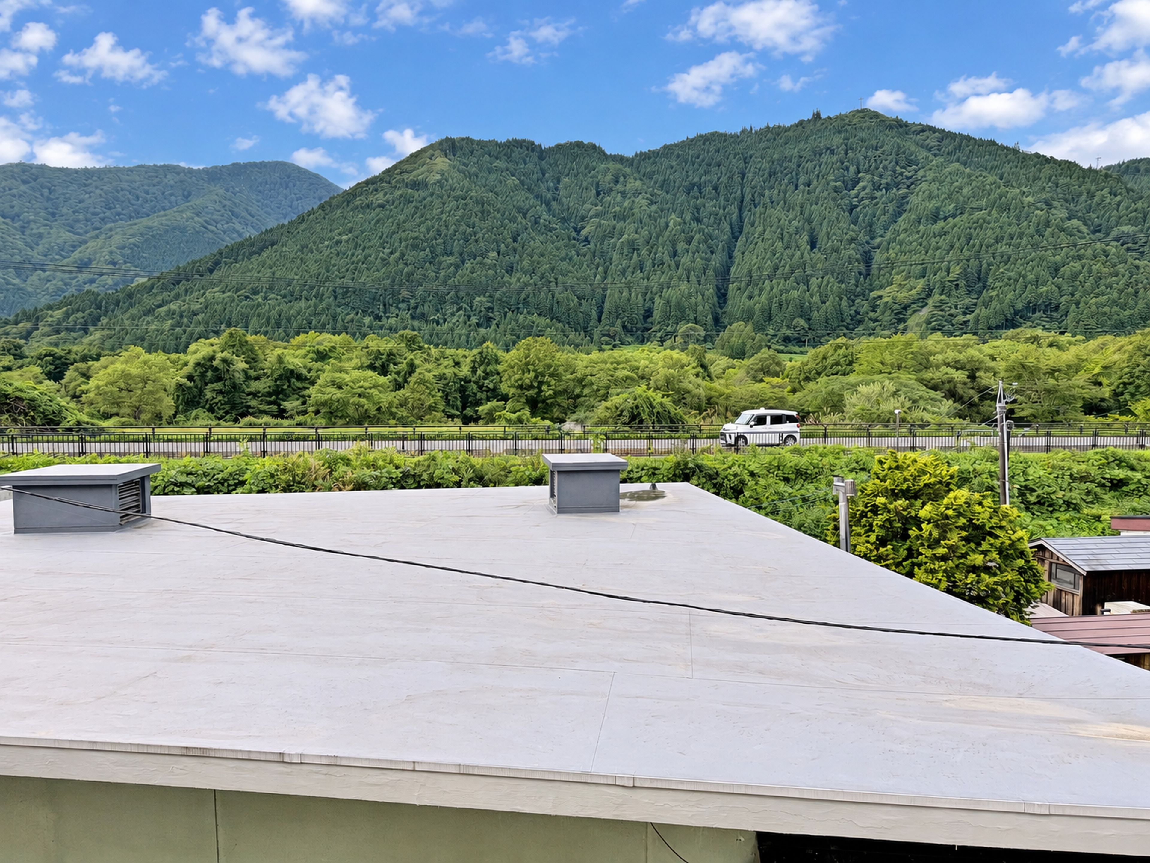 A rooftop with a view of a forested mountain range.