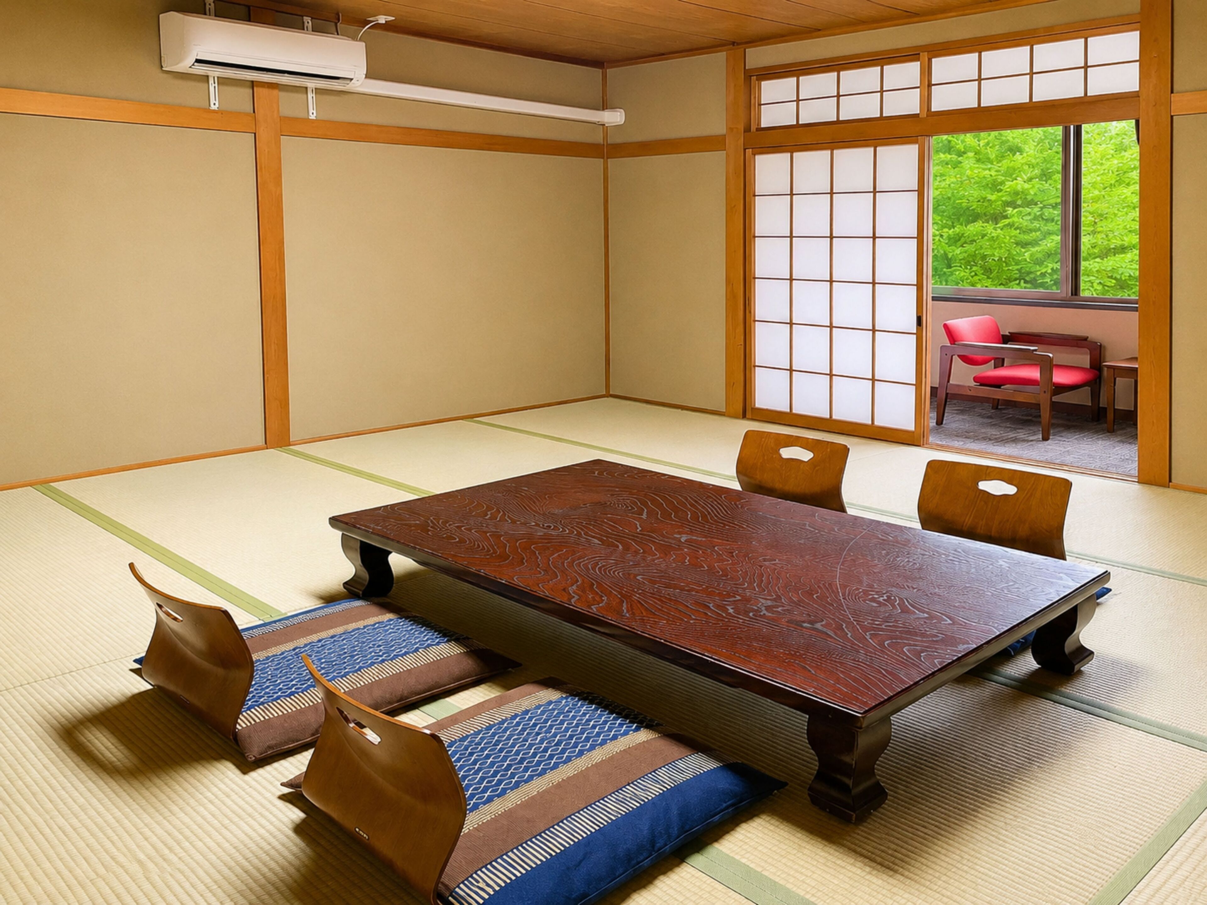 A tatami room with a low wooden table, cushions, and a sliding door leading to an outdoor area.