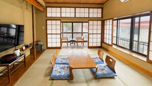 A traditional Japanese room with tatami flooring, a low wooden table, and shoji screens.