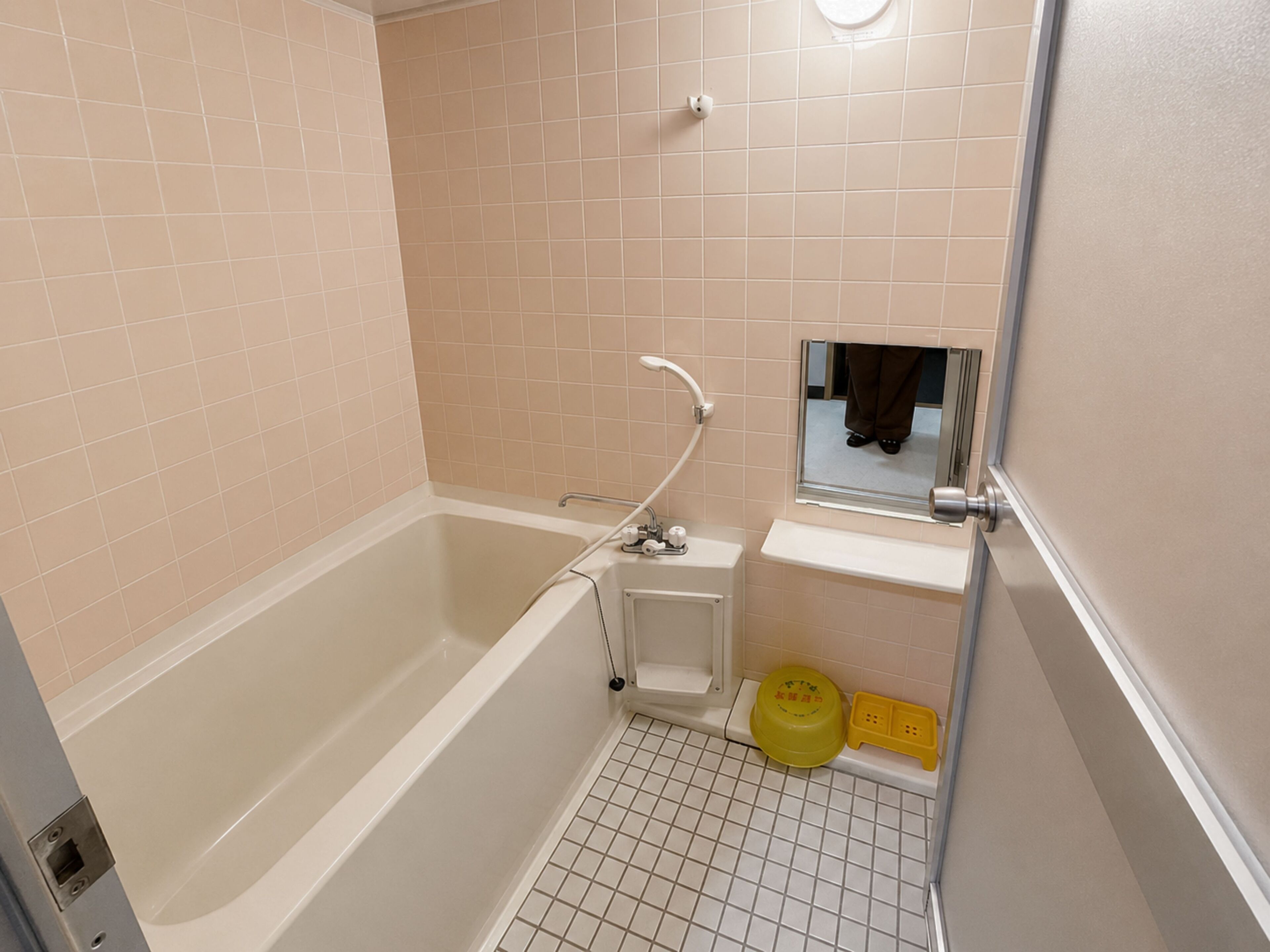 A bathroom with a bathtub, a sink, and a mirror.
