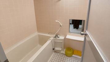 A bathroom with a bathtub, a sink, and a mirror.