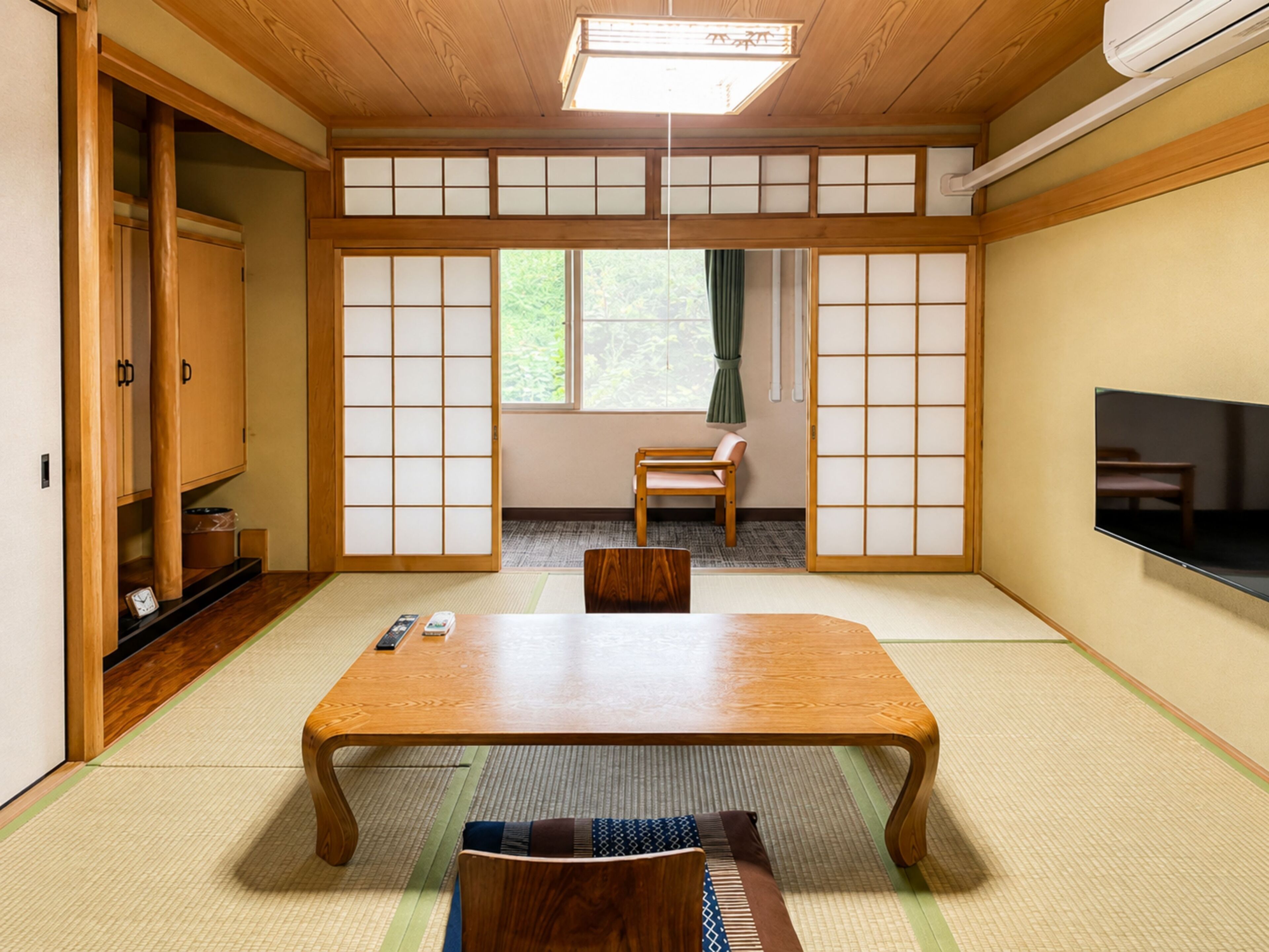 A traditional Japanese-style room with tatami flooring, a low table, and sliding doors.