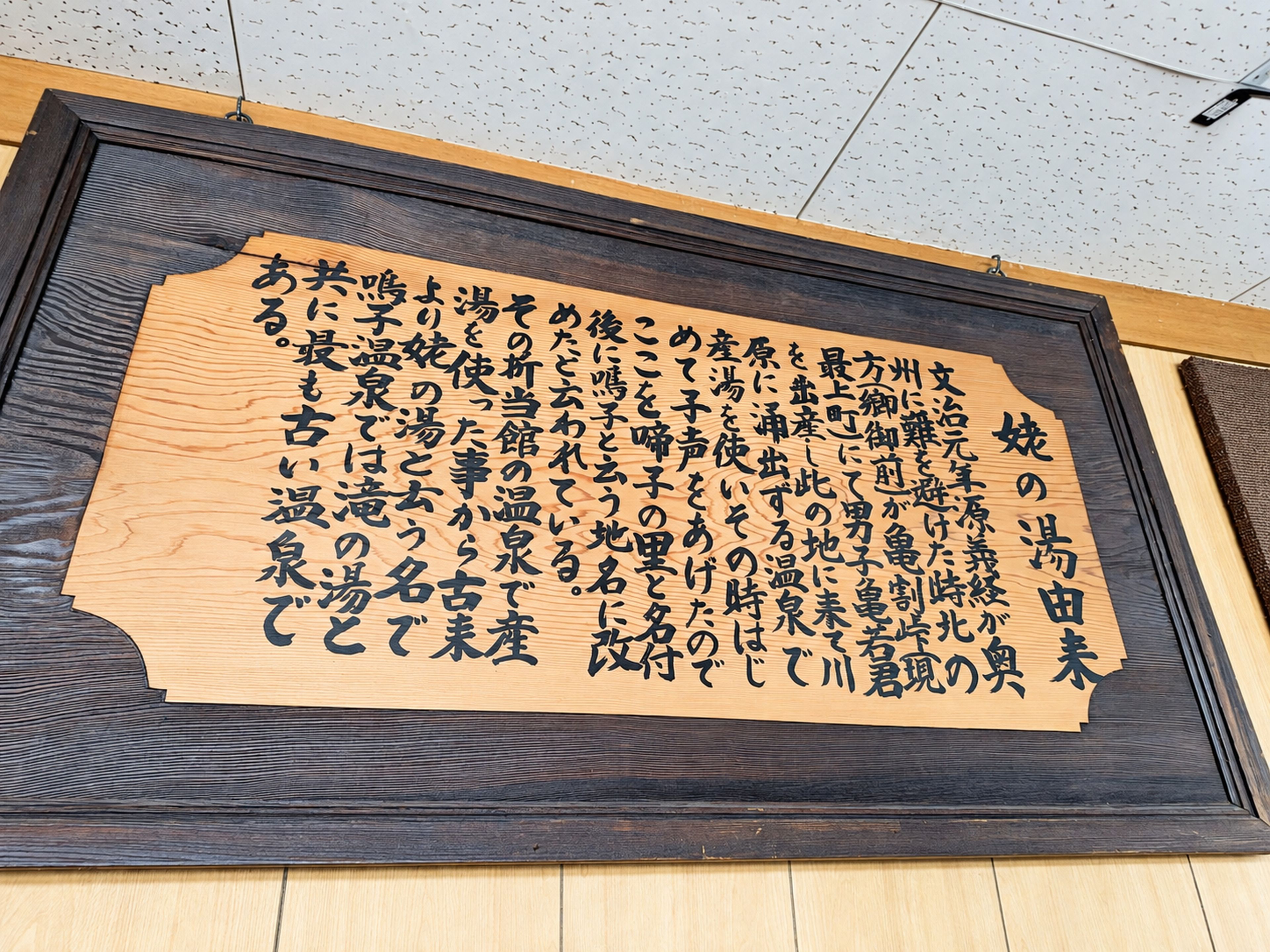 Texto japonês emoldurado em uma parede.