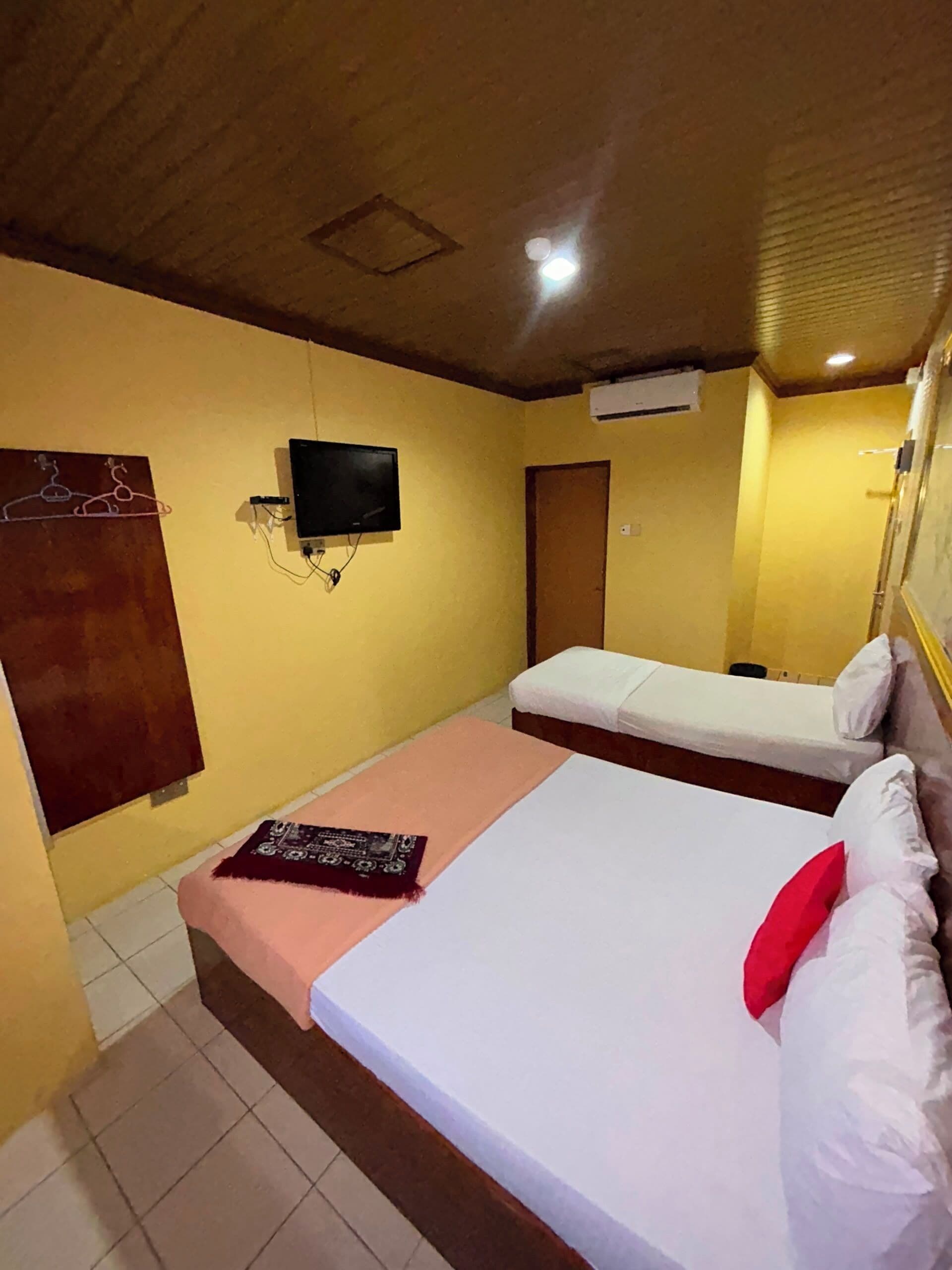 A hotel room with a bed, a television, and a small table.