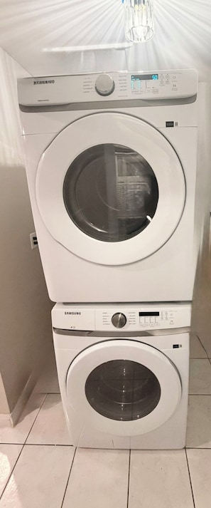 A stacked washer and dryer unit with a control panel and a digital display.