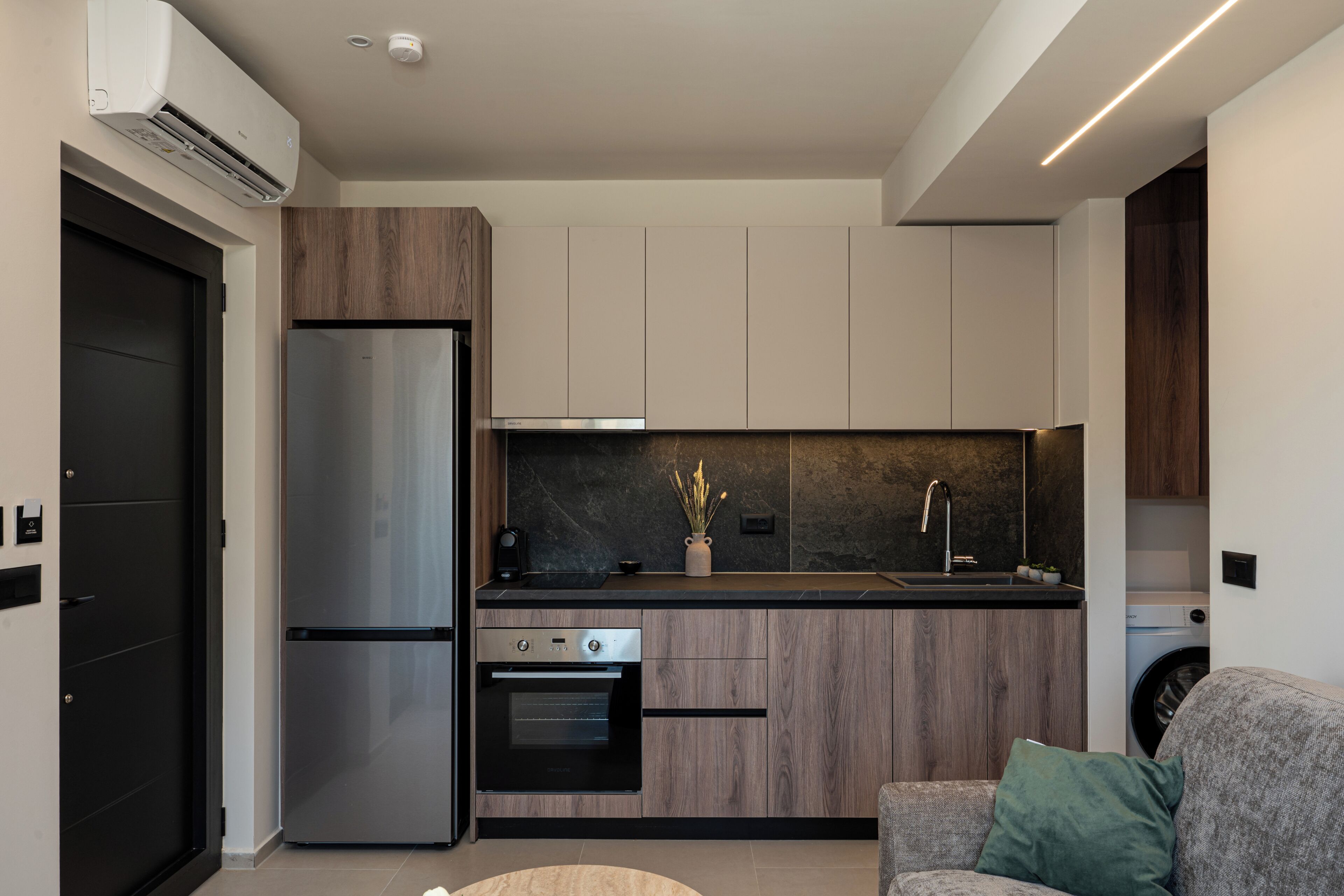 A modern kitchen with a built-in oven, a refrigerator, and a microwave.
