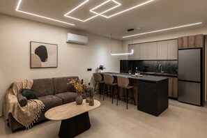 Uma cozinha moderna com uma ilha central, banquetas e uma geladeira embutida.