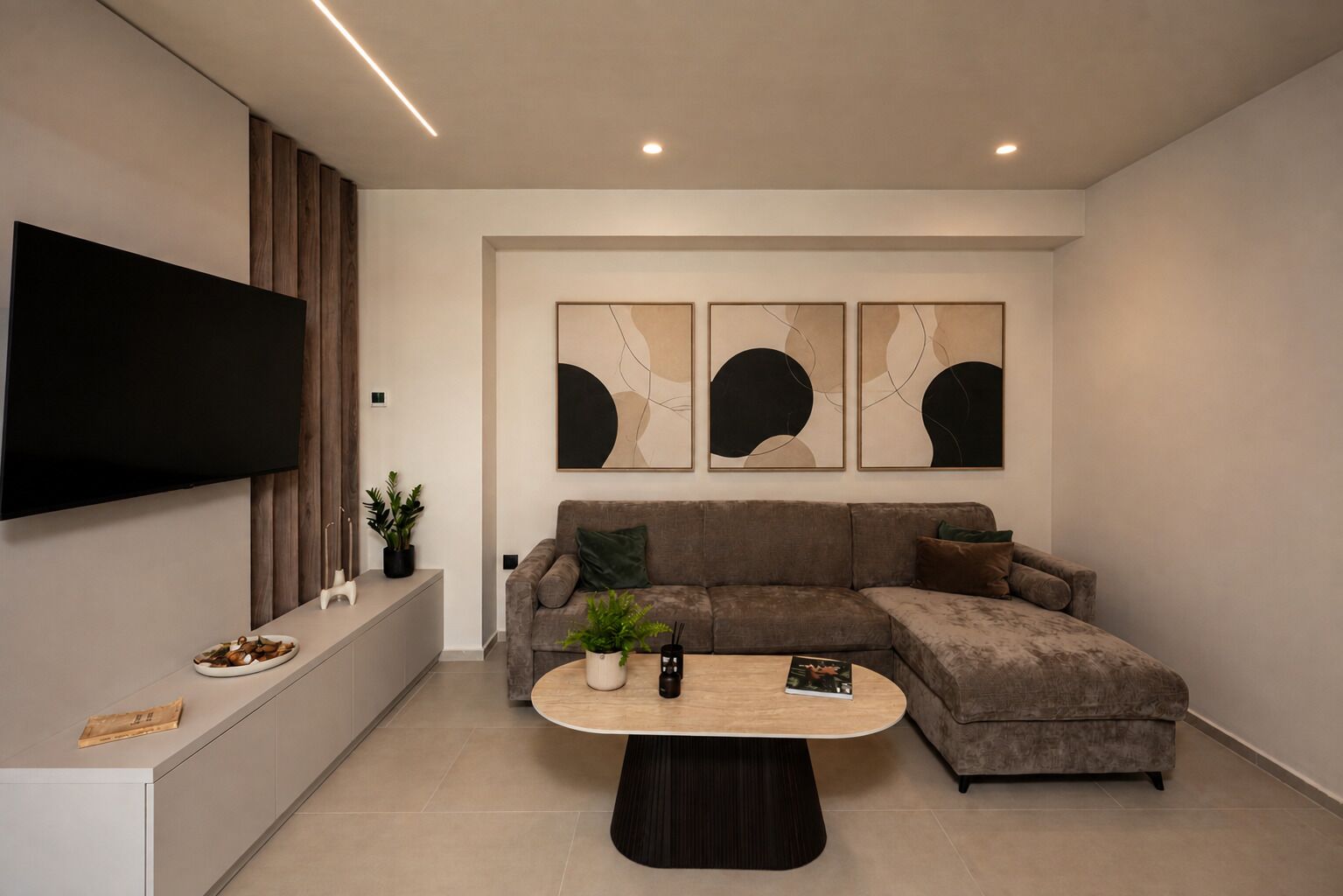 A modern living room with a sectional sofa, a coffee table, and abstract wall art.