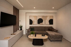 Uma sala de estar moderna com um sofá seccional, uma mesa de centro e arte abstrata na parede.
