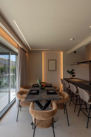 Uma área de jantar moderna com uma mesa, cadeiras e vista para o exterior.