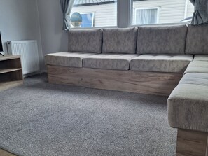 A living room with a grey sofa, a wooden coffee table, and a grey carpet. - Haven Seashore, Ellerton Willerby Xtra (Great Yarmouth)