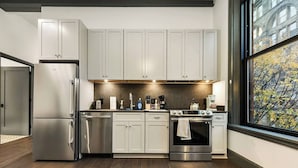 A modern kitchen with stainless steel appliances, a large window with a view, and wooden flooring. - Comfortable 2BR — Conveni (Pittsburgh)