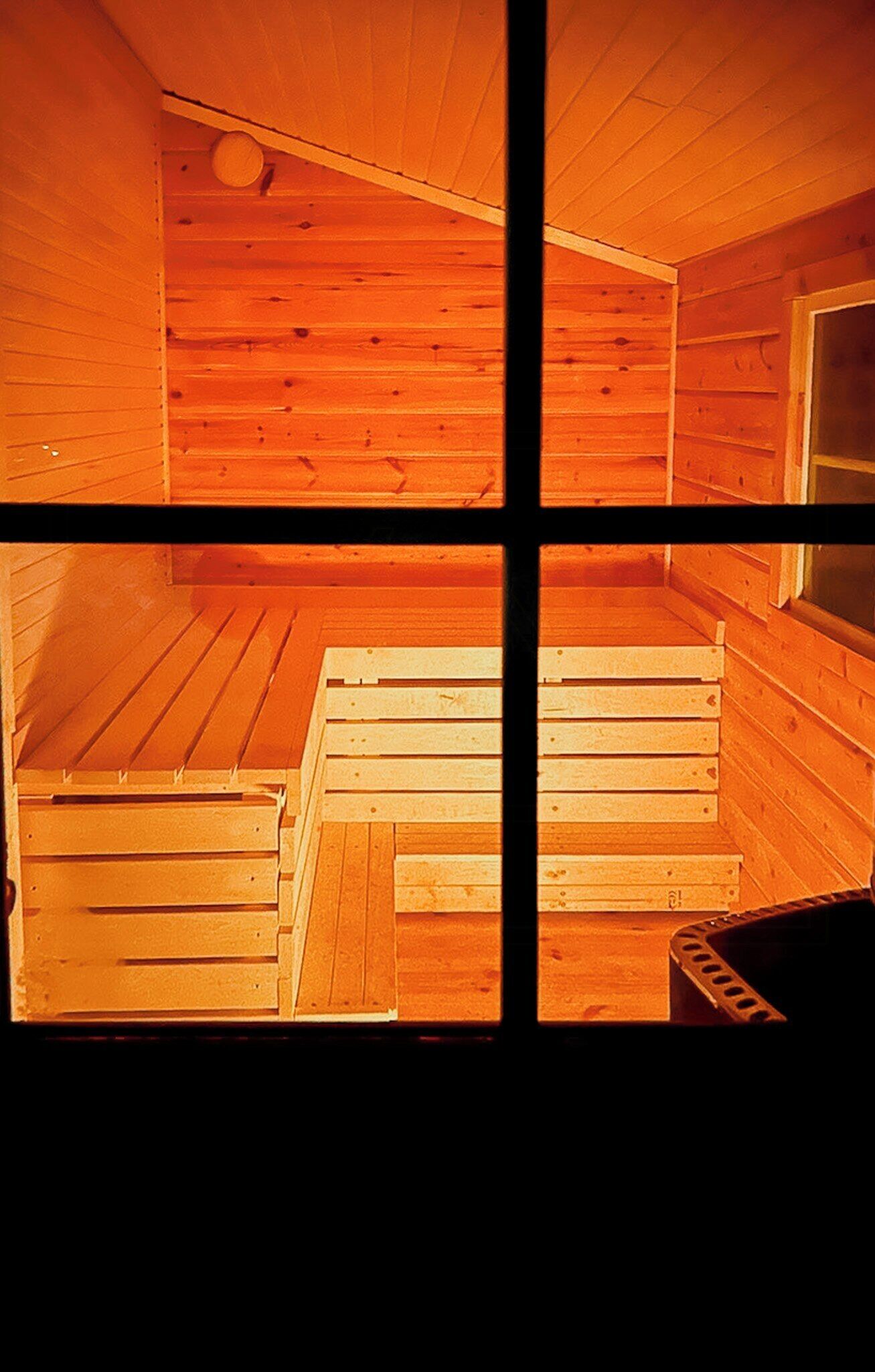Een sauna met houten banken en een raam.