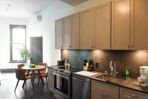 Modern kitchen with stainless appliances and a cozy window-side dining nook - Cozy 1BR Downtown | Walkable to NFL (Pittsburgh)