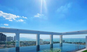 Piscina infinita en la azotea con vistas despejadas a la ciudad y al océano.