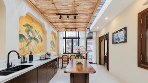 Una cocina moderna con una isla de madera, un fregadero y un comedor con sillas.