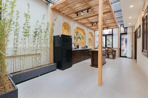 A modern kitchen with a black refrigerator, wooden ceiling, and a dining area with a table and chairs. - Lily Hidden Homestay Spacious 150m² 2BR near Hoan Kiem Lake (Hanoi, Vietnam)