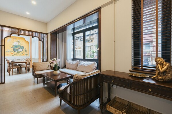 A traditional-style living room with a sofa, dining table, and a decorative Buddha statue. - Lily Hidden Homestay Spacious 150m² 2BR near Hoan Kiem Lake (Hanoi, Vietnam)