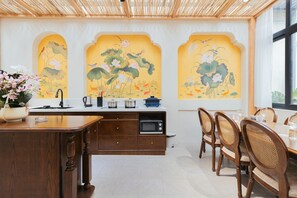 Una cucina in stile tradizionale con mobili in legno, forno a microonde integrato e zona pranzo con sedie e tavolo in legno.