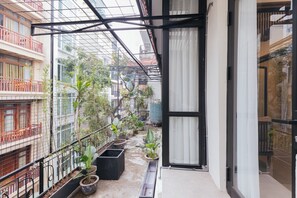 A narrow balcony with potted plants, a metal railing, and a view of neighboring buildings. - Lily Hidden Homestay Spacious 150m² 2BR near Hoan Kiem Lake (Hanoi, Vietnam)