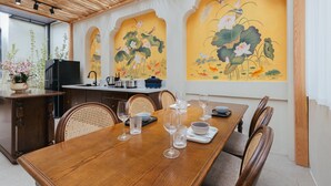 Un comedor con una mesa de madera dispuesta para seis personas, rodeada de sillas de mimbre.