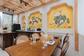 A dining area with a wooden table set for six, surrounded by wicker chairs. - Lily Hidden Homestay Spacious 150m² 2BR near Hoan Kiem Lake (Hanoi, Vietnam)