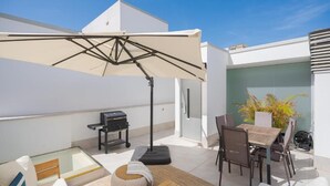A rooftop terrace with a dining table, chairs, a grill, and a large umbrella. - Fahana Canteras (LAS PALMAS DE GRAN CANARIA)