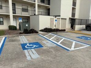 Ein Parkplatz mit ausgewiesenen Behindertenparkplätzen, markiert mit blauer Farbe und Rollstuhlsymbolen.