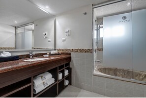 Ein modernes Badezimmer mit großem Spiegel, Waschbecken, Badewanne und Dusche.
