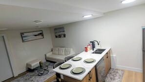 A compact kitchen with a central island, a built-in sink, and a refrigerator.