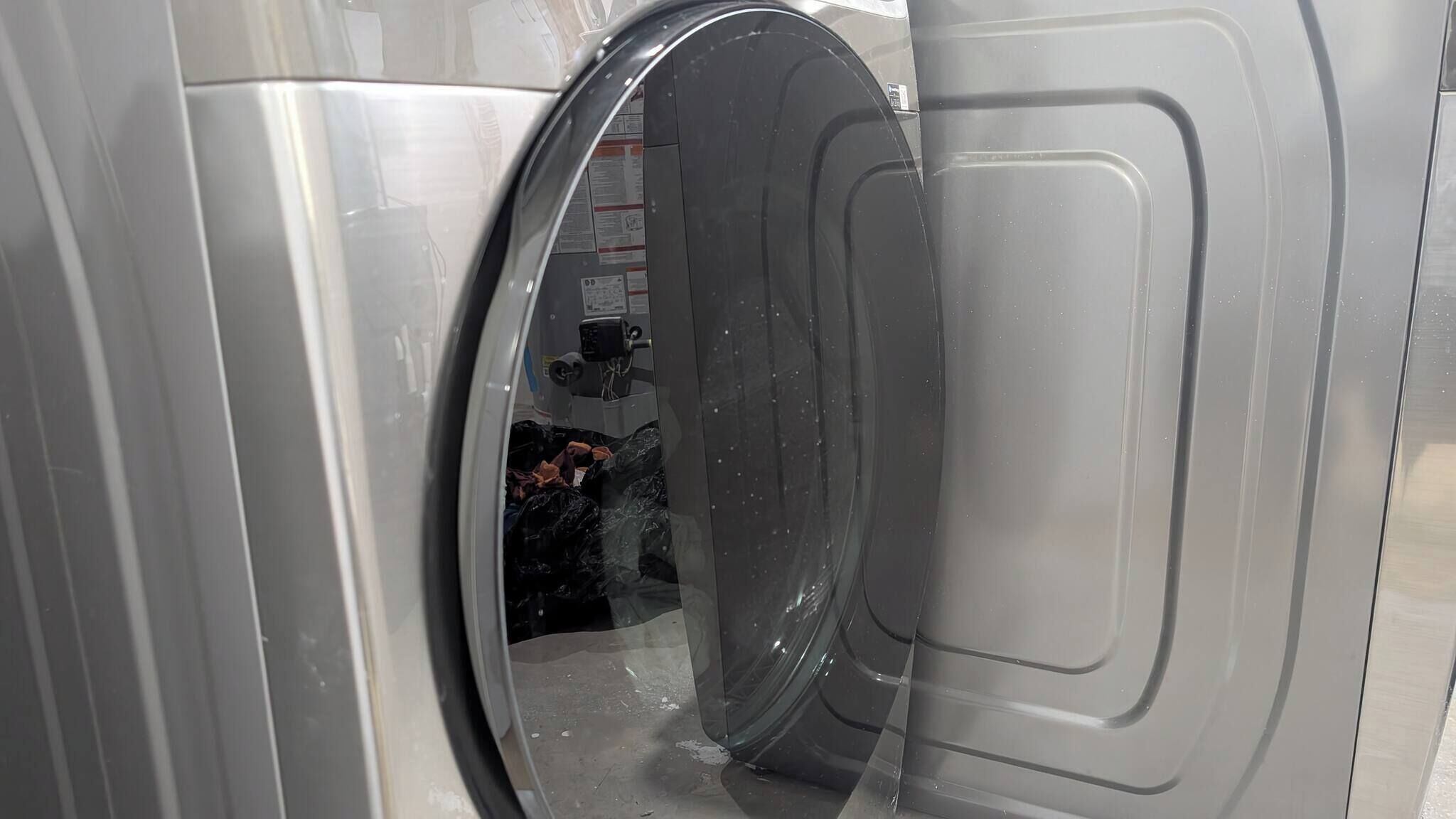 A front view of a washing machine with a transparent door, revealing the interior.