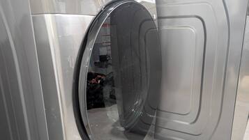 A front view of a washing machine with a transparent door, revealing the interior.
