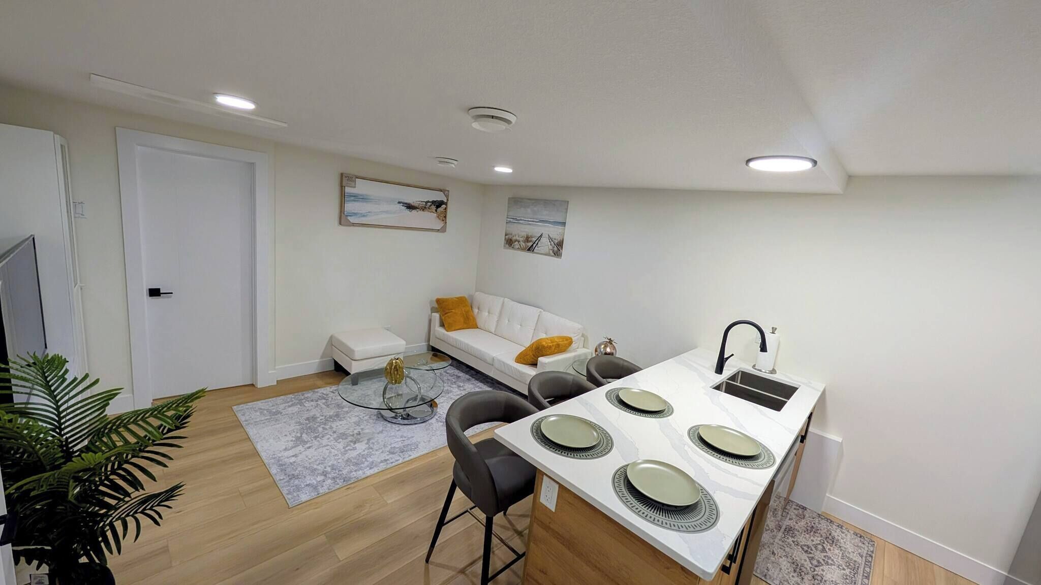 A compact living space with a dining area, a sofa, and a small kitchen.