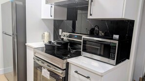 A modern kitchen with stainless steel appliances, including a refrigerator, oven, stove, and microwave.