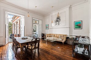 A spacious room with a wooden dining table, a sofa, and a coffee table. - Wilde Cedar with swimming pool (Binfield)