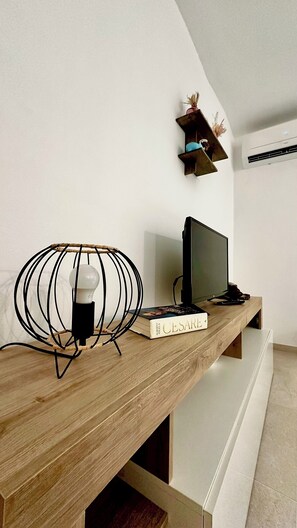 Un bureau en bois avec un écran d’ordinateur, une lampe et un livre intitulé « CESARE ».