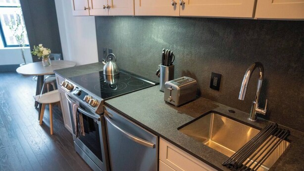 A modern kitchen with stainless steel appliances, a sink, and a toaster. - Urban 1BR Downtown–Close (Pittsburgh)